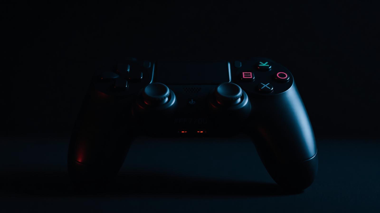 Dark game controller with subtle orange ambient lighting and deep black background